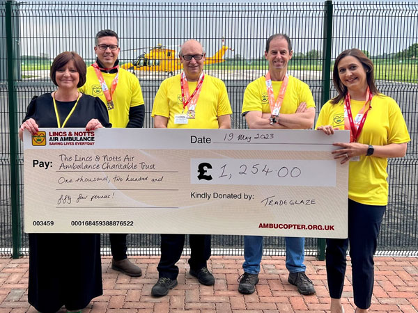Tradeglaze team handing over cheque to the Lincs and Notts air ambulance after running Lincoln 10k